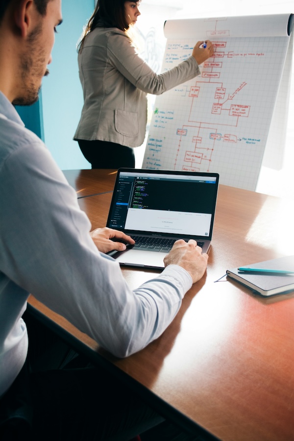 Mujer y hombre trabajando en equipo, usando un chart